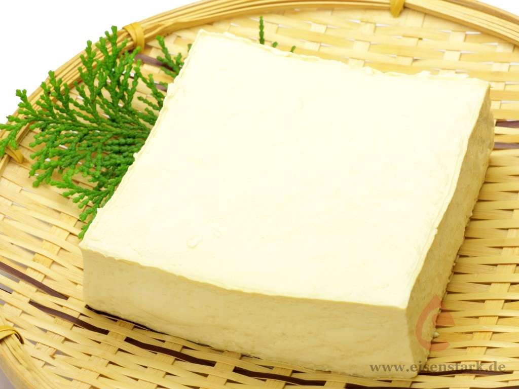 Ein Block aus Tofu auf einer Bambusmatte