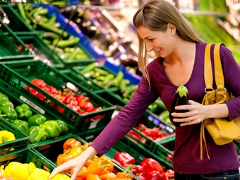 Frau in der Gemüseabteilung eines Supermarktes