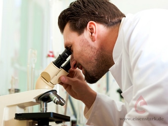Mann analysiert mit Mikroskop